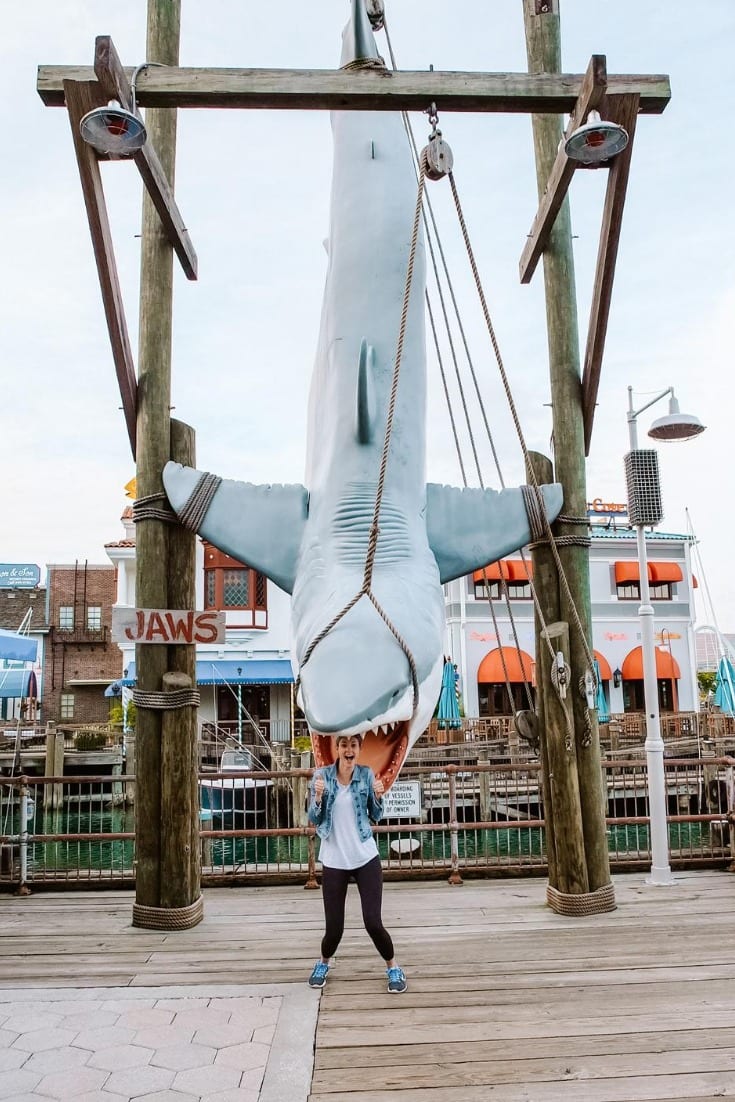 girl posing under hanging shark