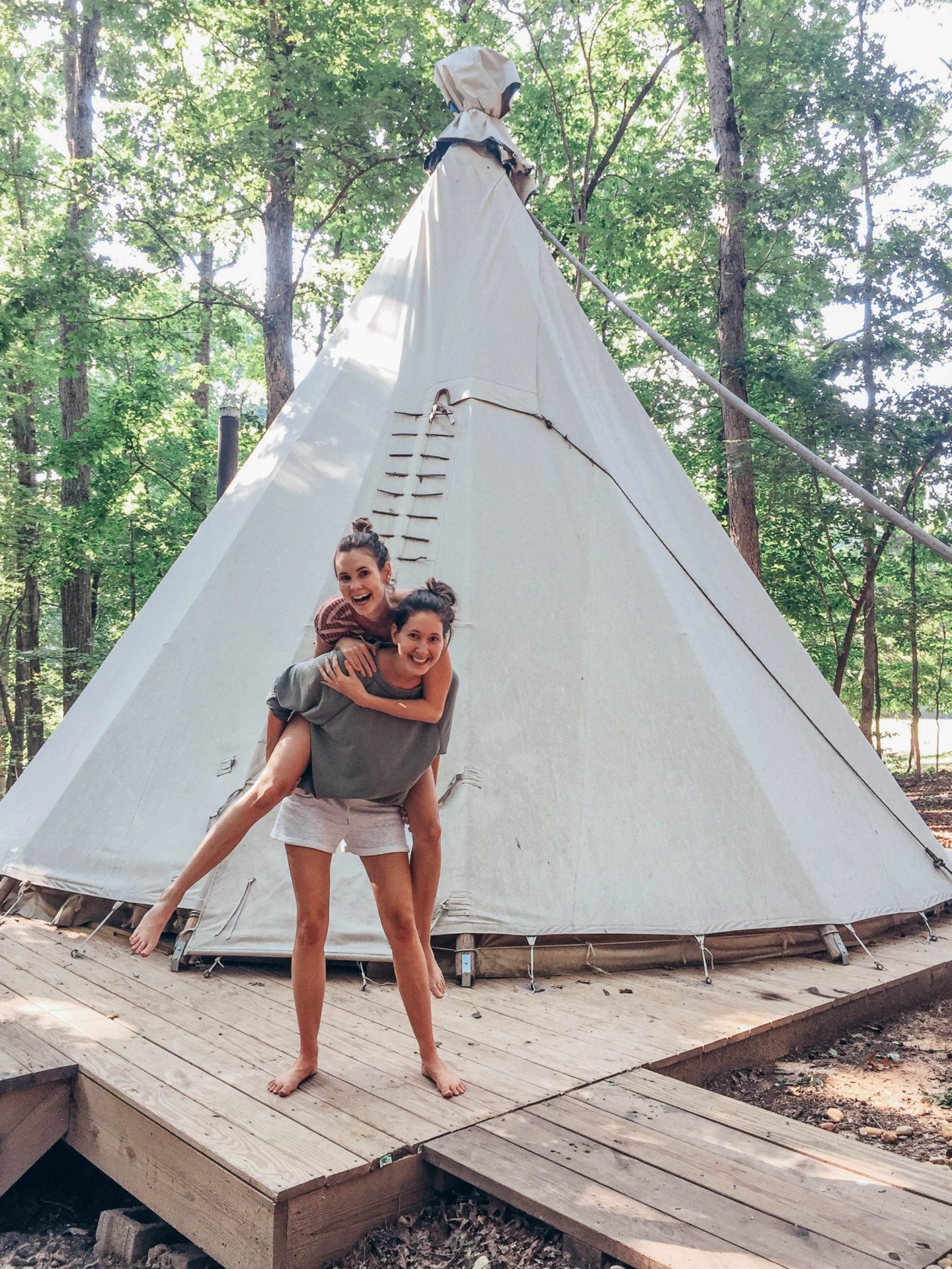 girls standing in front of a Indian tipi 
