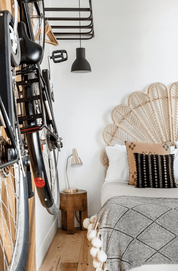 bike hanging on the wall with a bed in the background