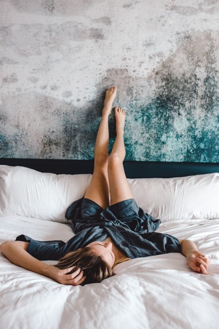 Girl laying on bed upside down