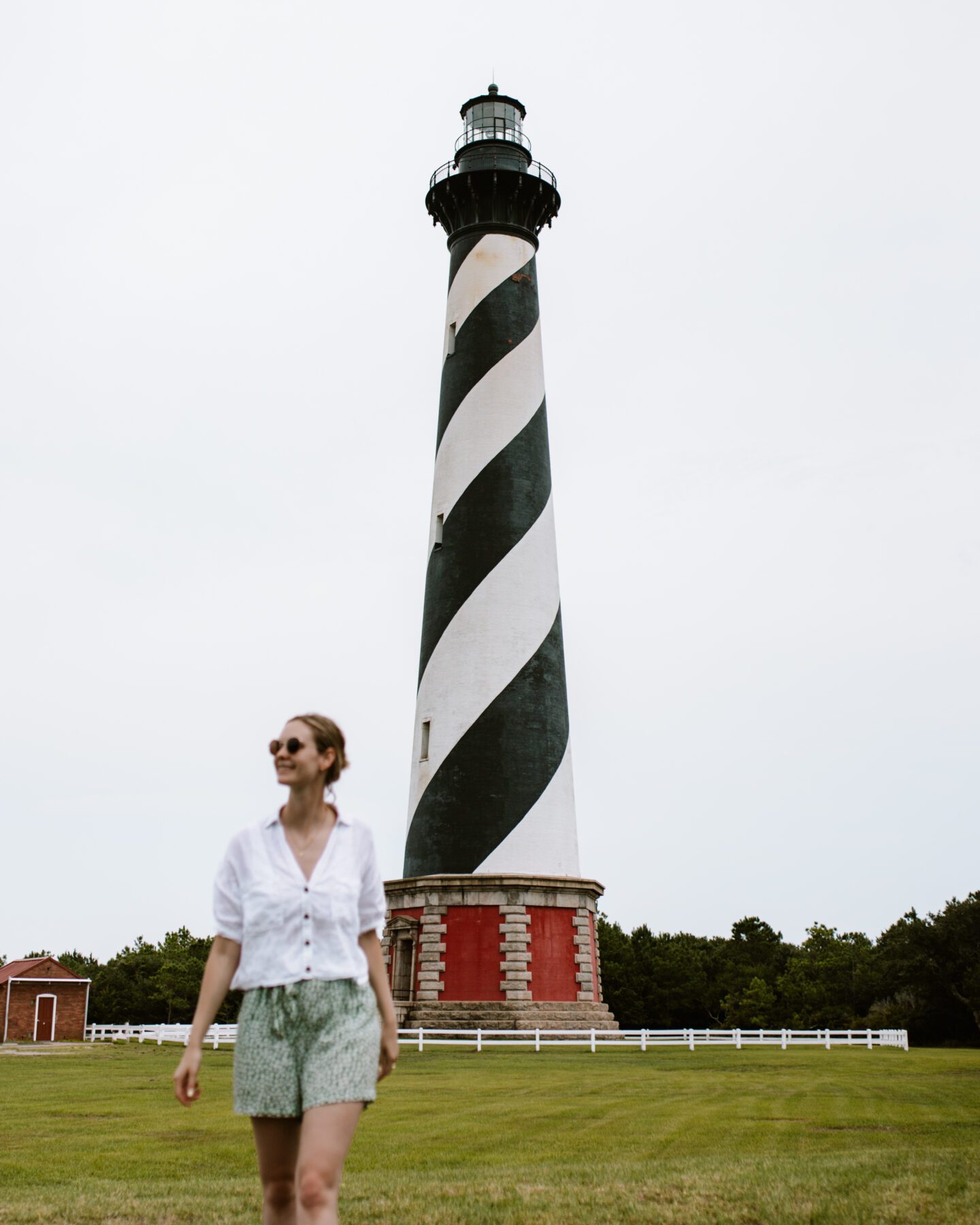 girl standing in front of a large lighthouse