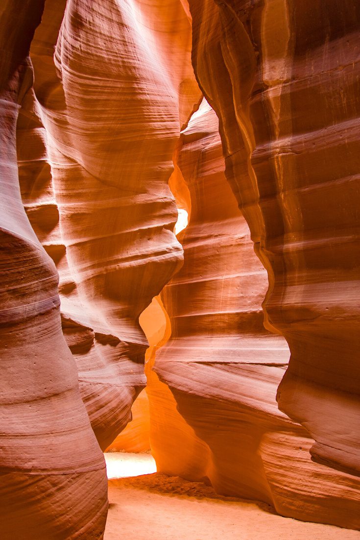 Tall orange sandstone walls in a slot canyon