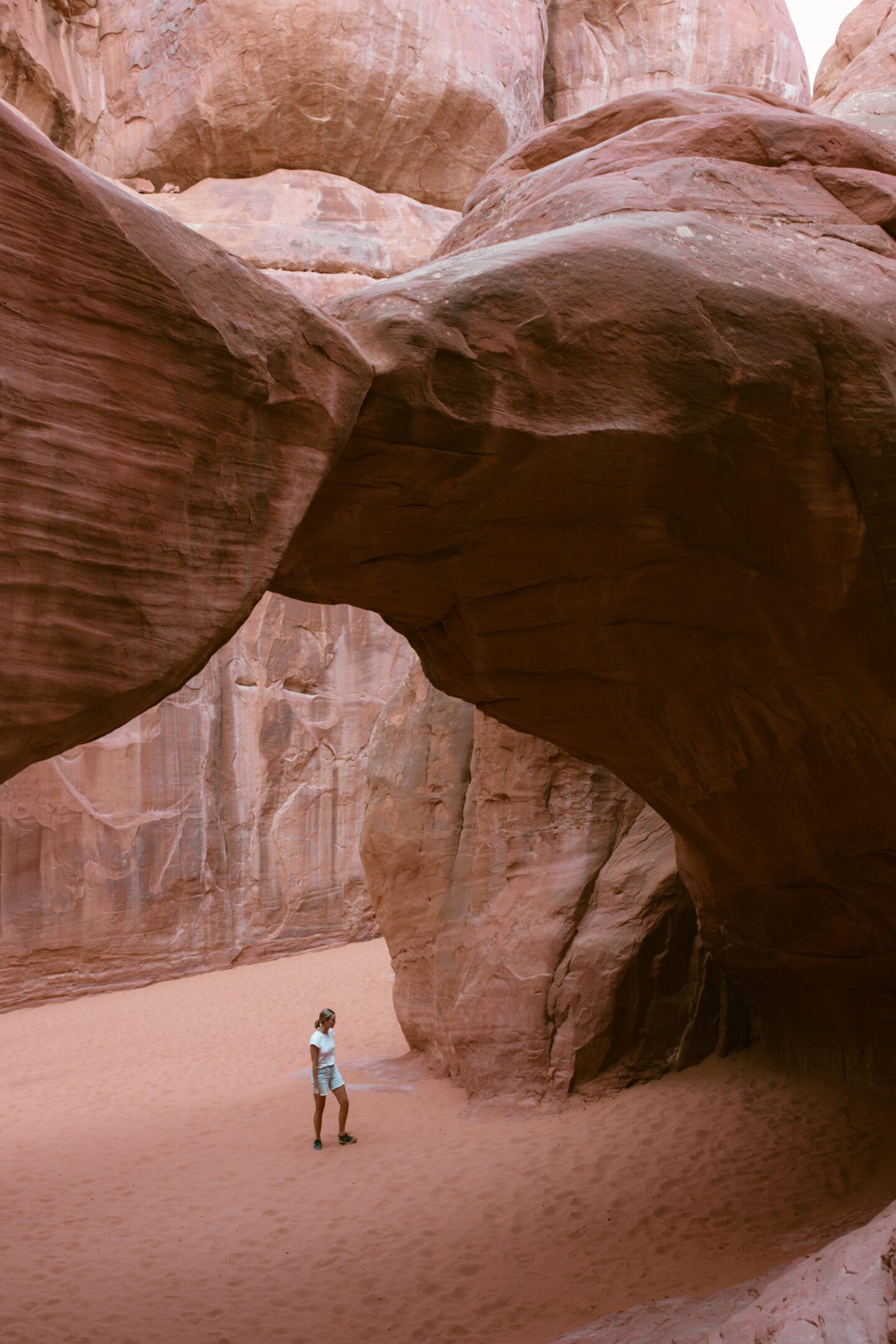 girl standing under a large rock arch