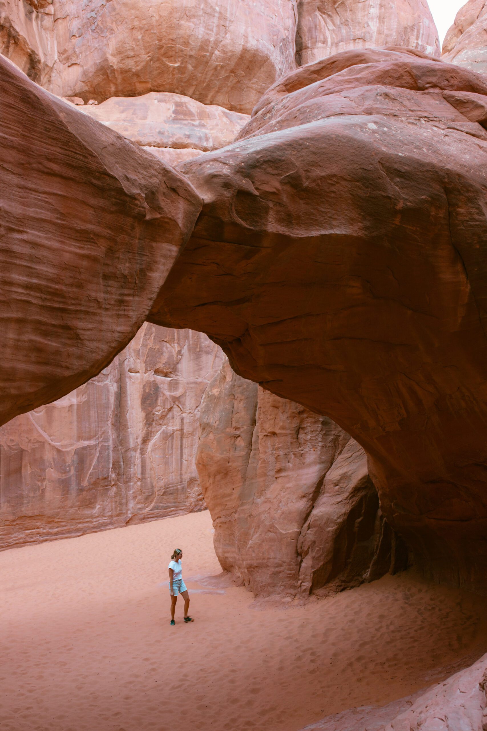 Girl standing underneath a rock archway