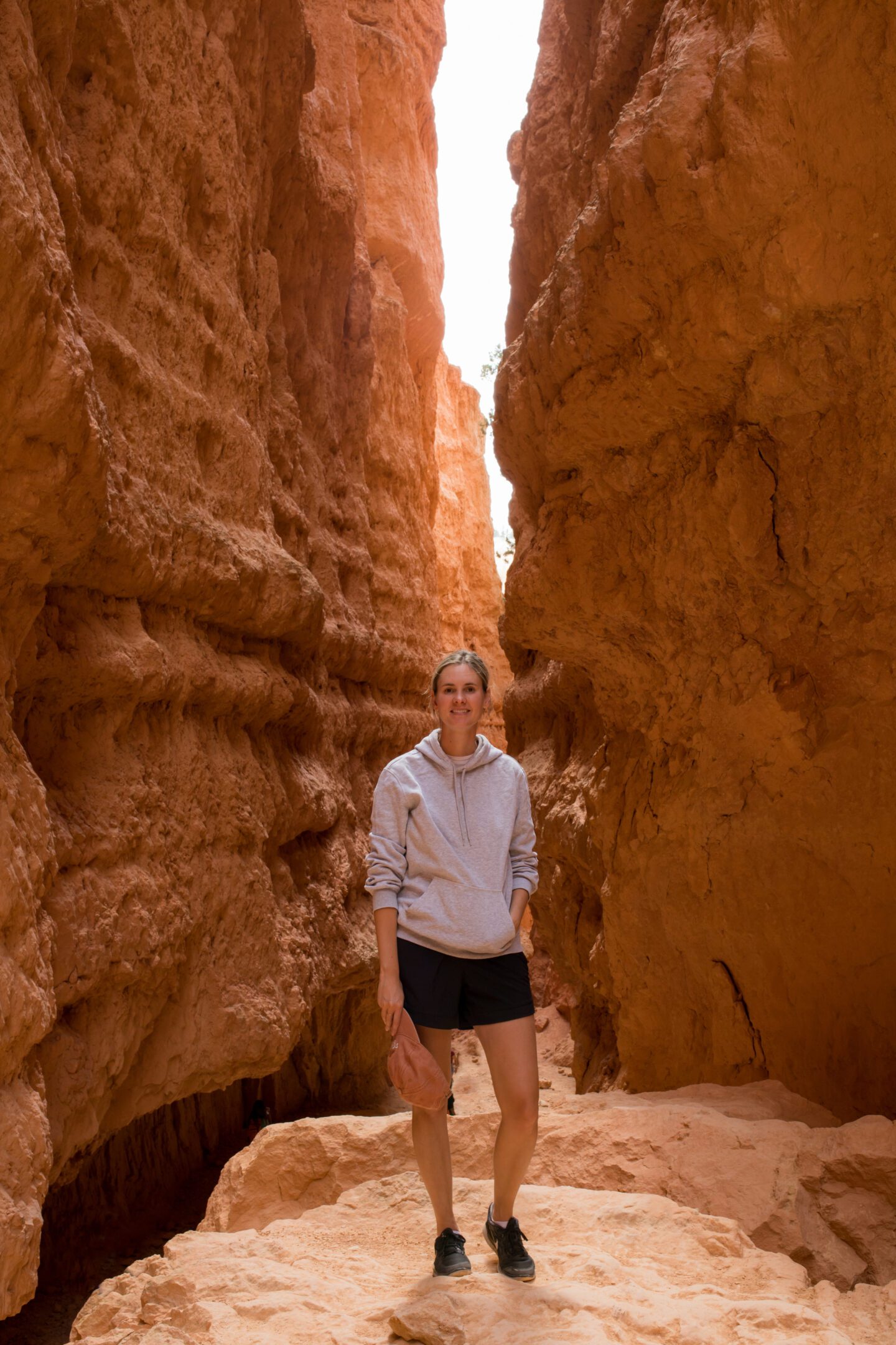 girl standing in front of a tall rock cave gap, 2 week west coast USA itinerary 