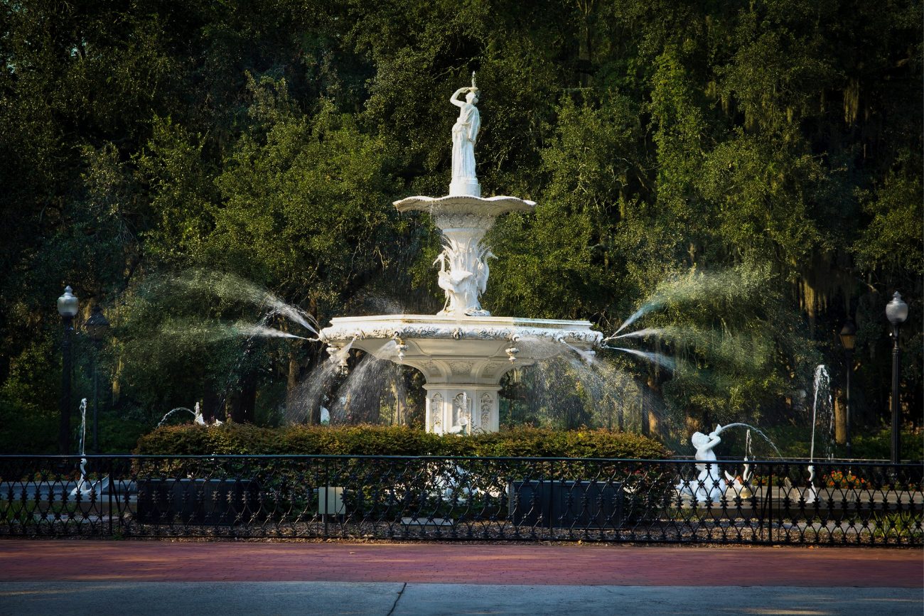 A large white water fountain in a park