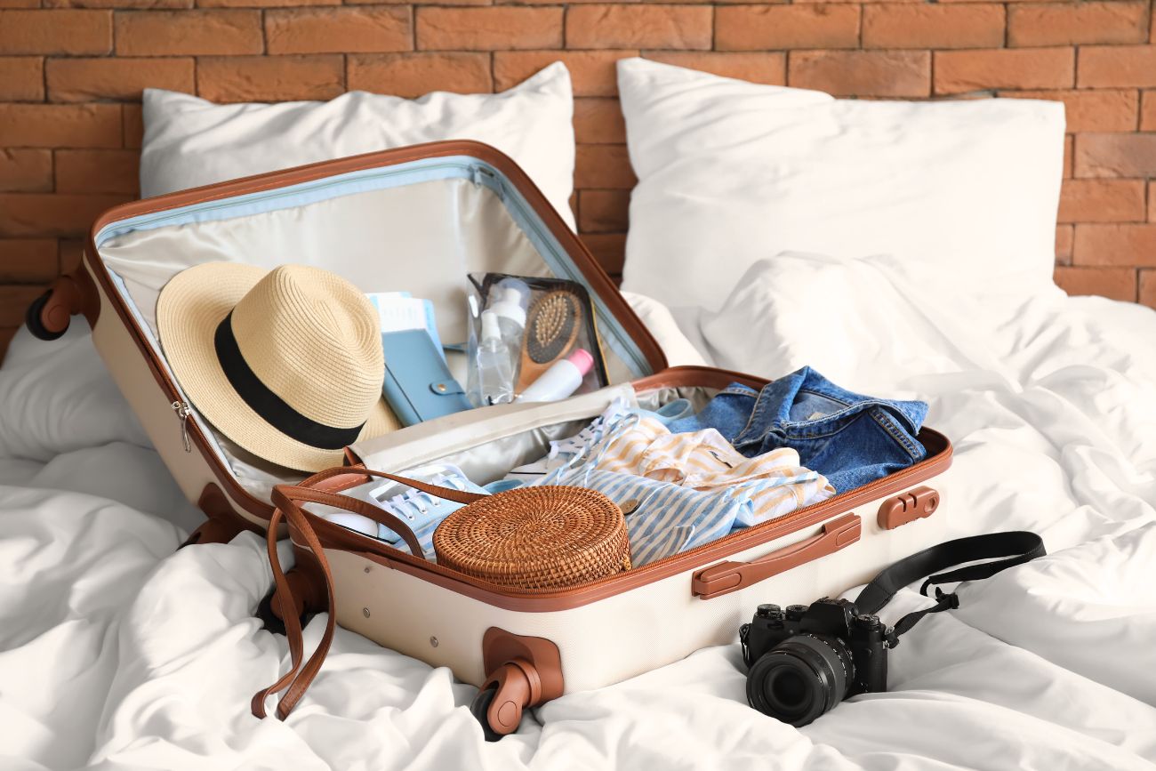 suitcase on a bed with clothes and accessories, What to pack for a weekend trip