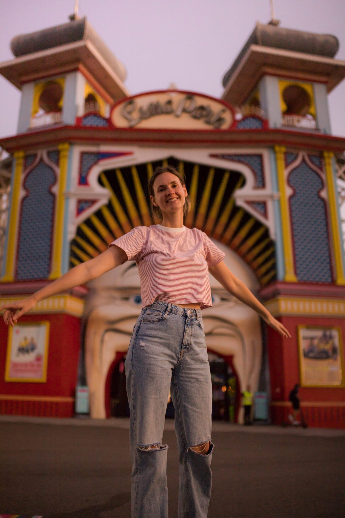 Girl standing in front of a amusement park entrance, things to do in st kilda melbourne