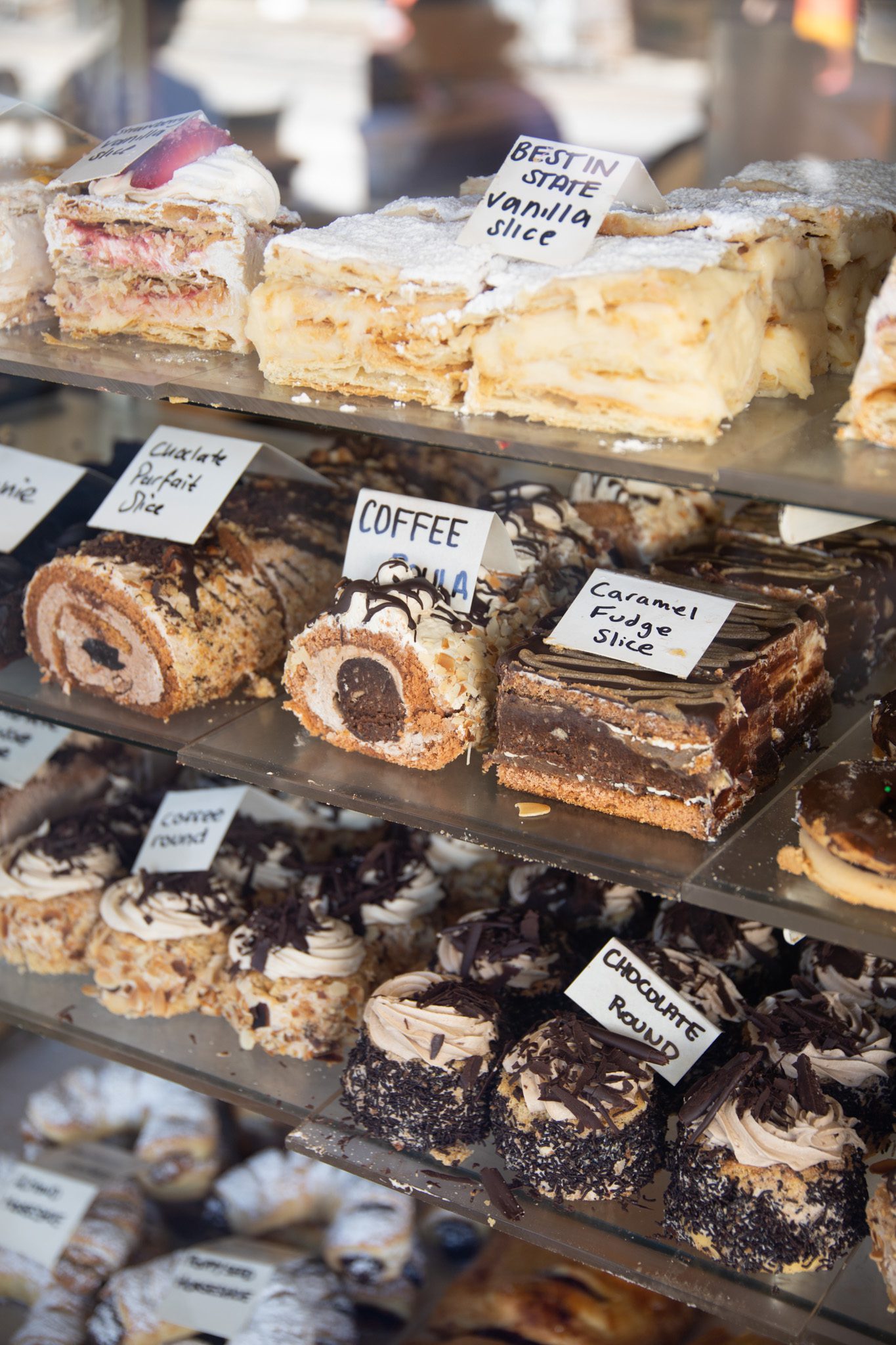A cabinet display of cakes, pastries and sweets, things to do in st kilda melbourne