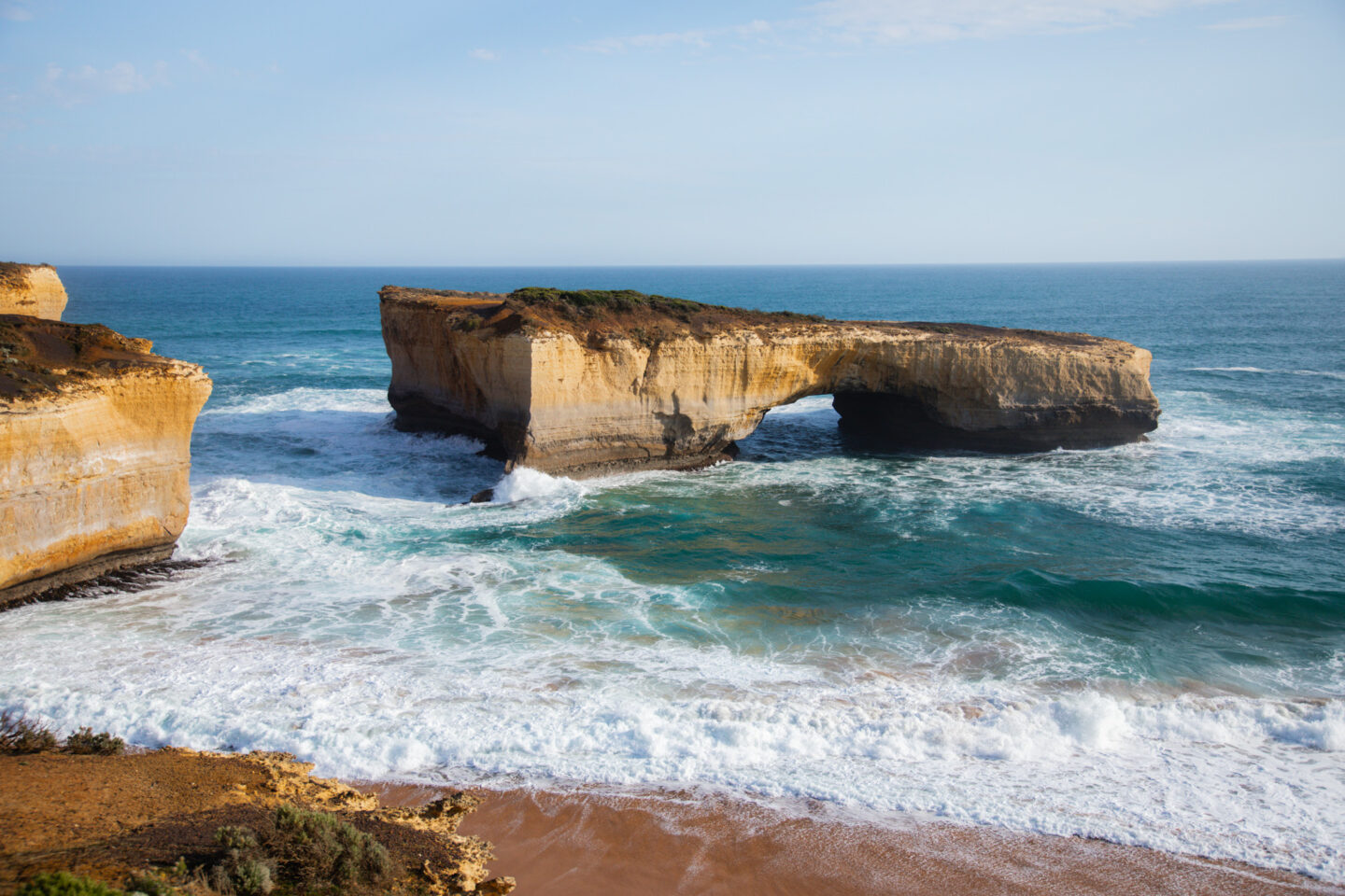 Great Ocean Road Day Trip From Melbourne, an arched rock formation in the ocean 